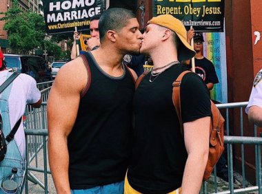 【反同抗议牌前的同性之吻，网友：用爱战胜仇恨】